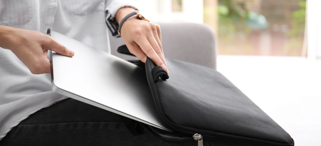 kobieta siedząca w kawiarni wkłada ultrabooka do torby