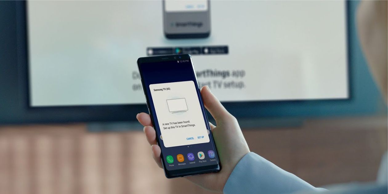osoba trzyma smartfon w ręku i łączy go bezprzewodowo z telewizorem LCD w technologii Samsung TV