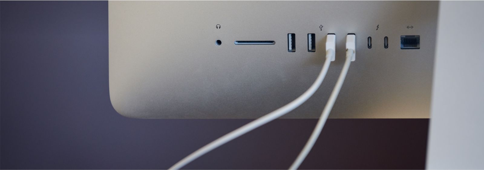 tył monitora Apple Studio Display z podpiętymi białymi kablami USB